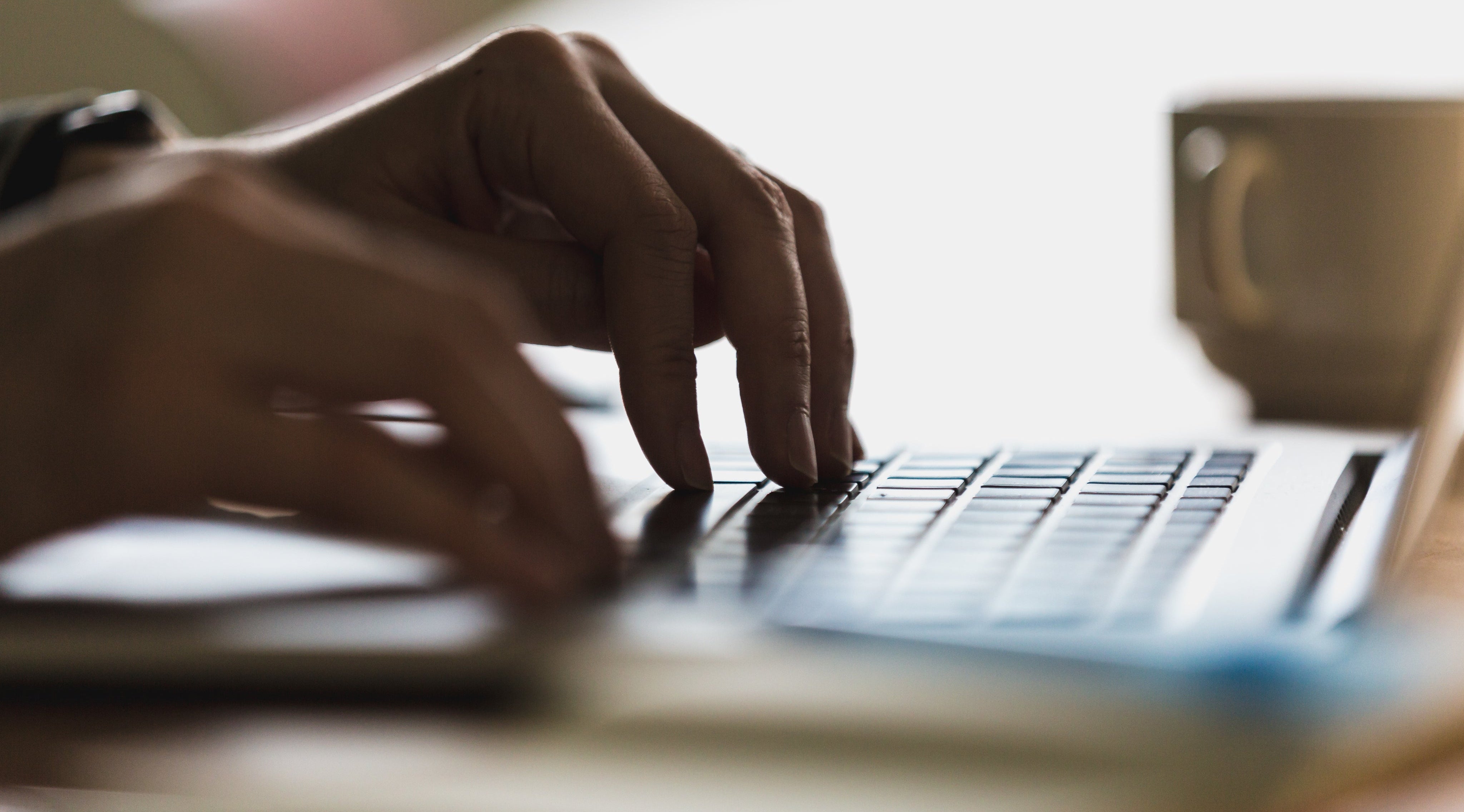 Customer typing review on laptop keyboard for XY-Global precision manufacturing services
